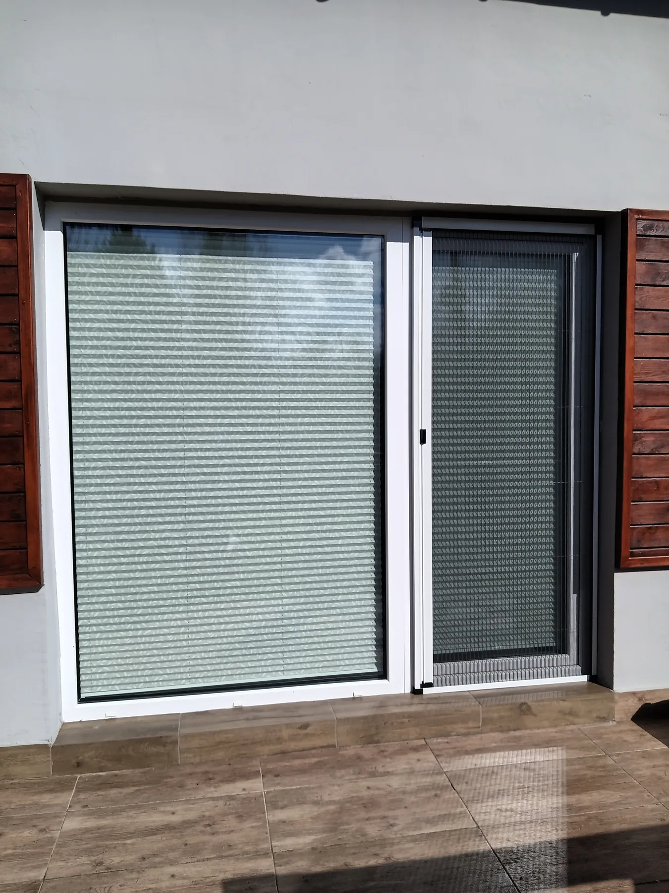 Moskitiera plisowana przy tarasie z drewnianą elewacją w realizacji na Śląsku - efekt końcowy po domknięciu moskitiery przy tarasie