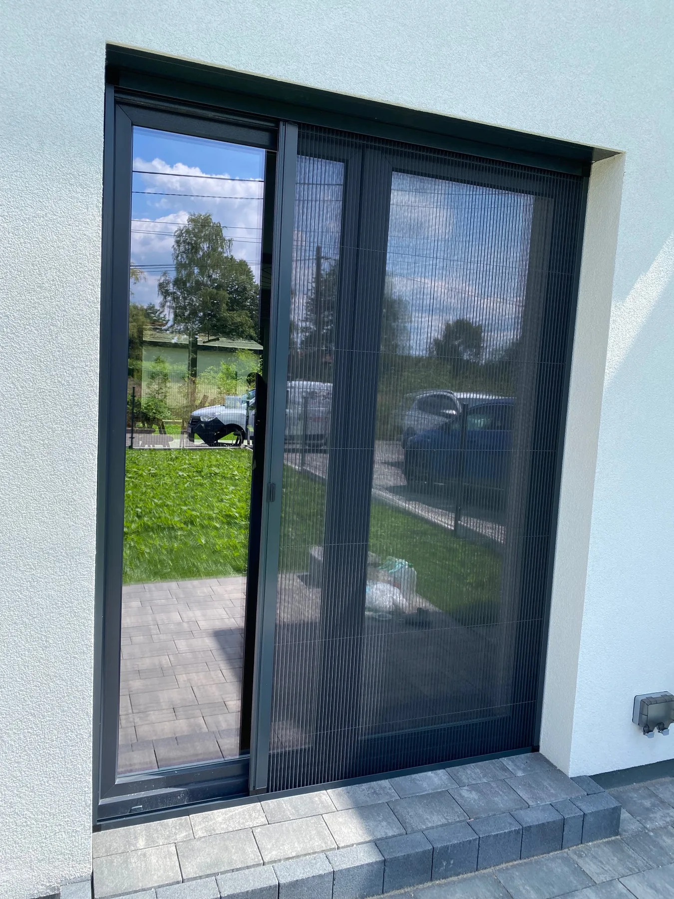 Moskitiera plisowana do wysokiego przeszklenia w realizacji na Śląsku - widok wysokiego przeszklenia z moskitierą