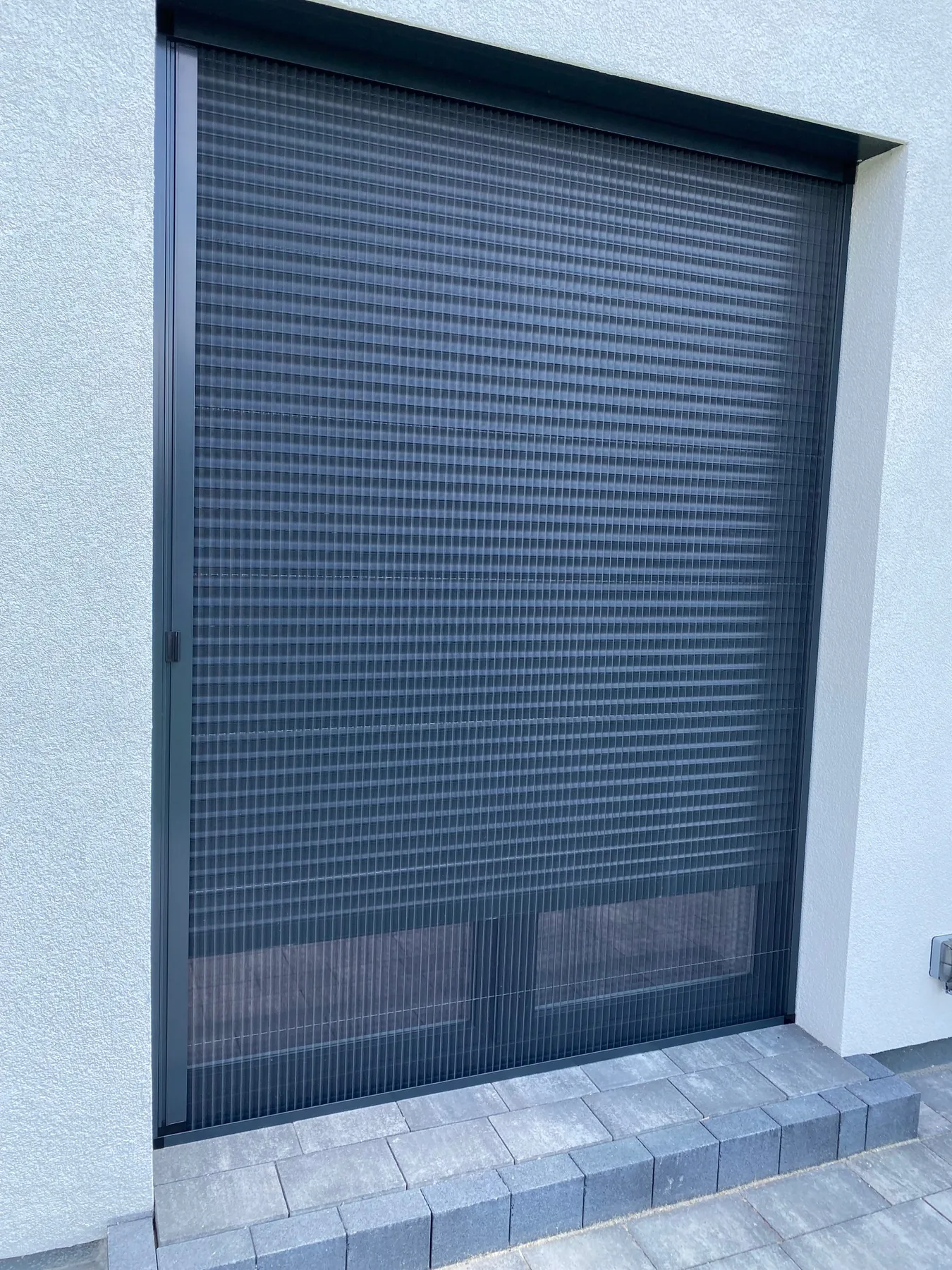 Moskitiera plisowana do wysokiego przeszklenia w realizacji na Śląsku - detal prowadzenia moskitiery przy dużym formacie