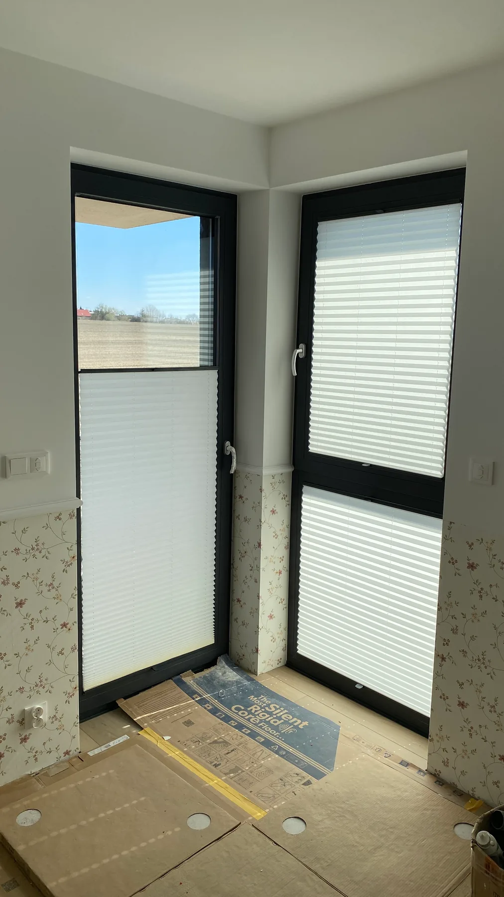 Plisy przy antracytowej stolarce w realizacji na Śląsku - ujęcie narożnego przeszklenia z plisami