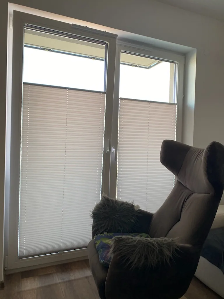 Plisy przy balkonowym przeszkleniu w realizacji na Śląsku - kadr drzwi balkonowych obok strefy wypoczynku