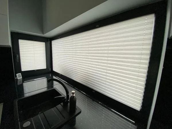 Plisy w czarnej kuchni w realizacji na Śląsku - widok narożnego układu okien nad blatem kuchennym