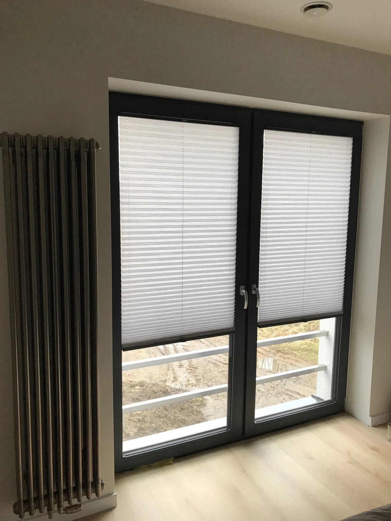 Plisy przy czarnej stolarce w realizacji na Śląsku - detal osłony na wysokim skrzydle drzwiowym