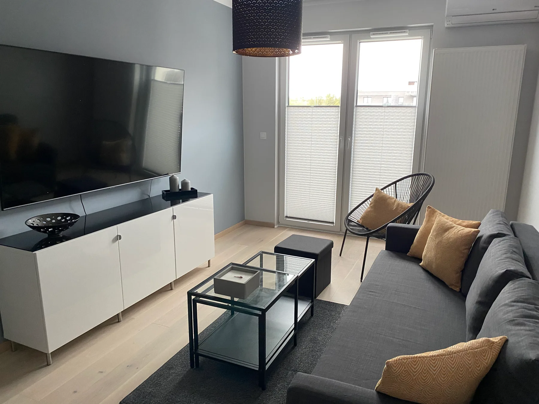 Plisy w salonie z szerokim przeszkleniem w realizacji na Śląsku - kadr drugiej strony strefy dziennej z plisami