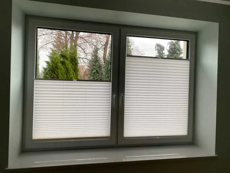 Plisy przy podwójnym oknie w szarej stolarce w realizacji na Śląsku - widok podwójnego okna z plisami ustawionymi od dołu
