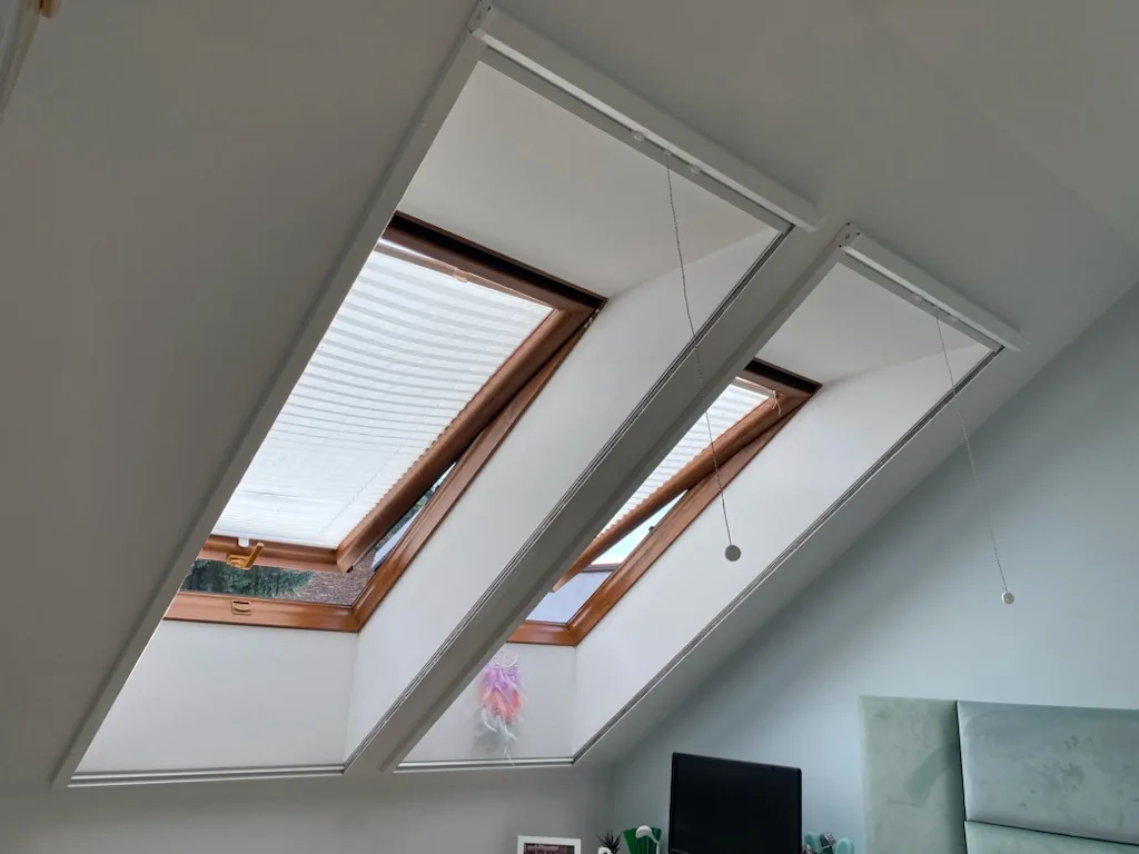 Moskitiera Vertica do okien dachowych w realizacji na Śląsku - ujęcie dwóch okien dachowych po montażu systemu