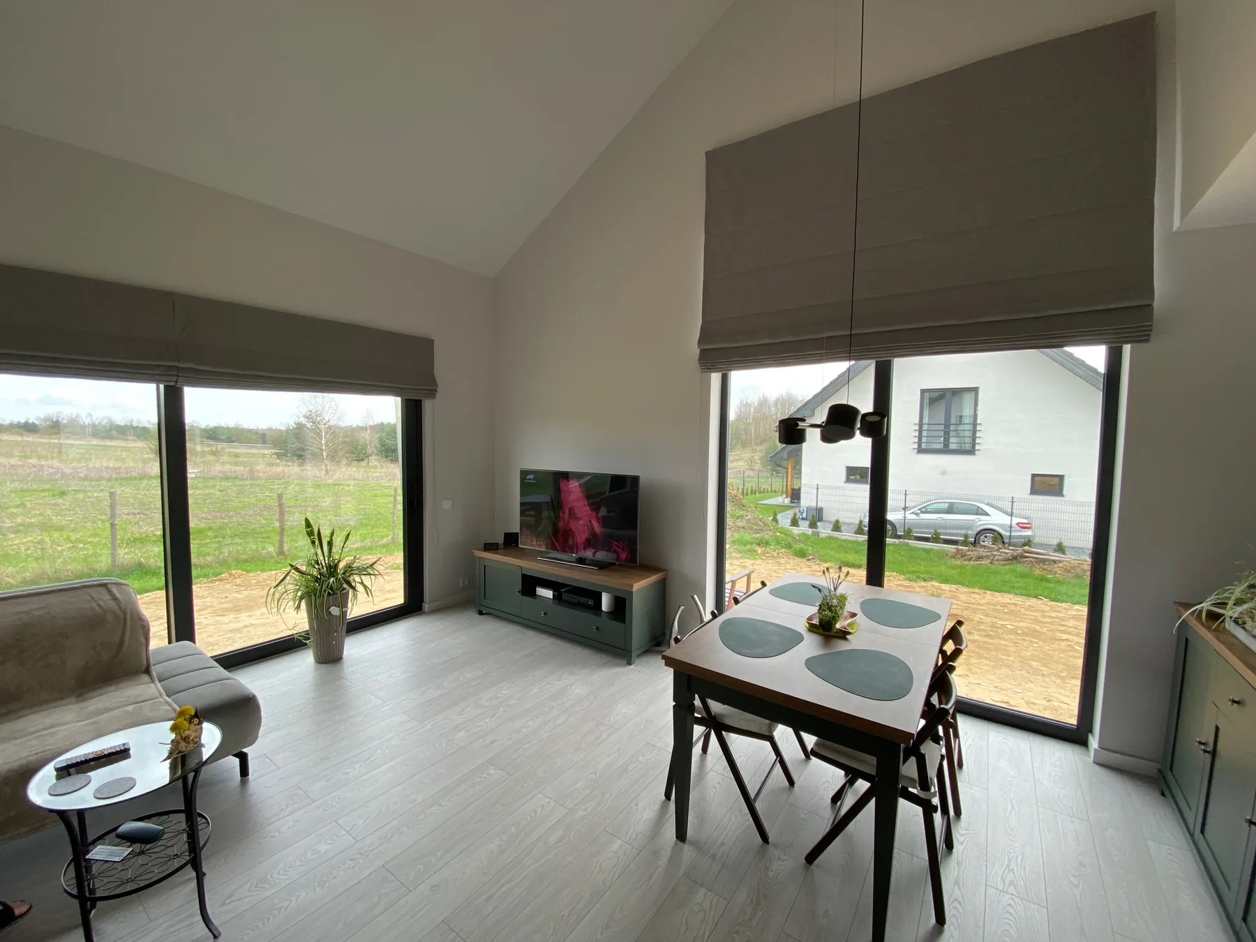 Rolety rzymskie przy narożnym przeszkleniu w realizacji w Jaworznie - kadr dwóch sąsiadujących okien w części dziennej