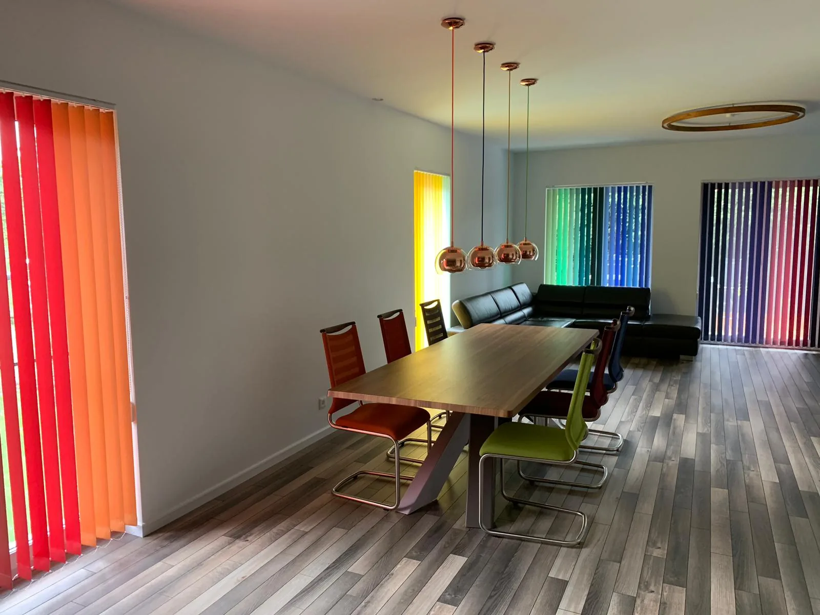 Żaluzje pionowe z kolorowymi lamelami w realizacji na Śląsku - kadr strefy dziennej z kilkoma zestawami żaluzji pionowych