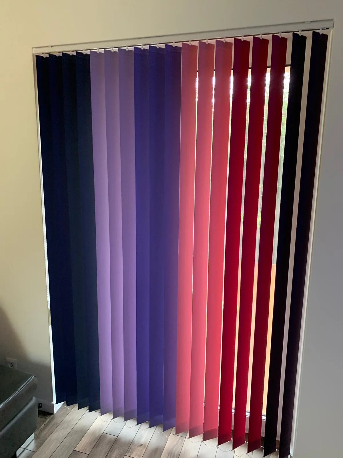 Żaluzje pionowe z kolorowymi lamelami w realizacji na Śląsku - ujęcie pionowych lameli w czerwonych i fioletowych tonach