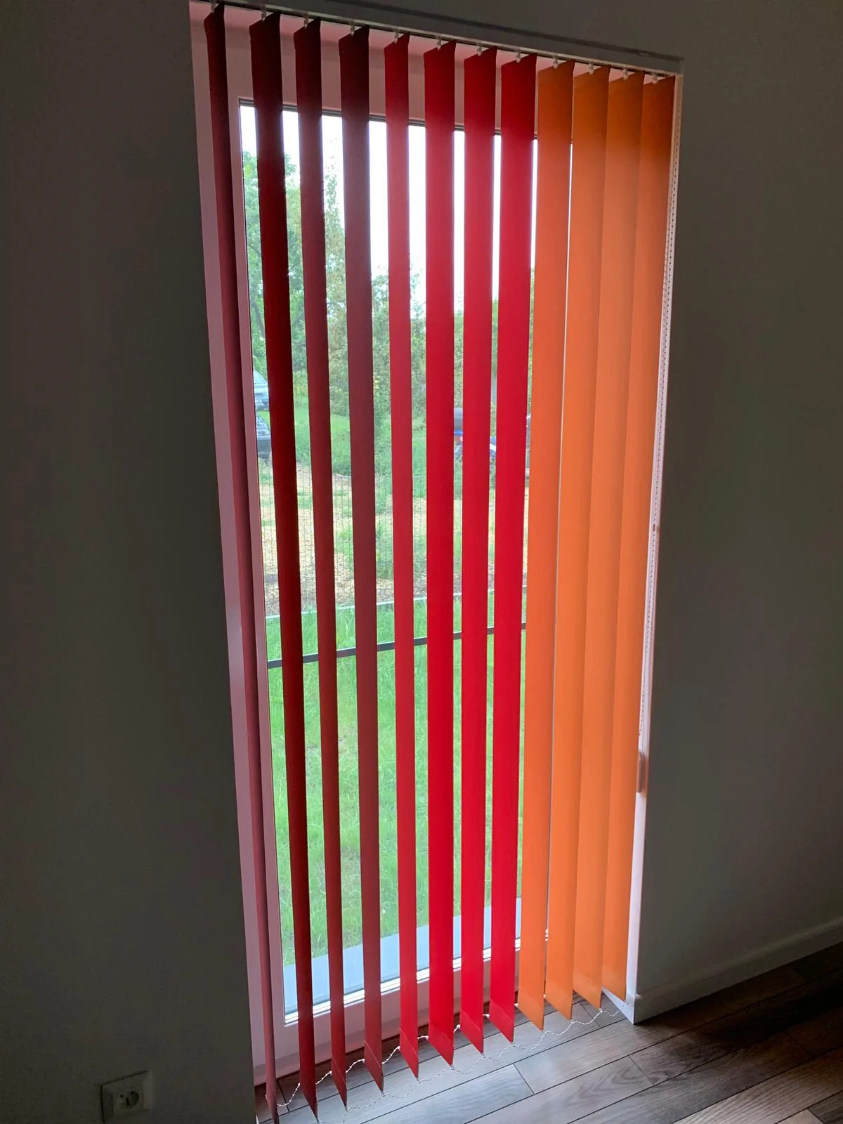 Żaluzje pionowe z kolorowymi lamelami w realizacji na Śląsku - detal kolorowego zestawu verticali przy oknie