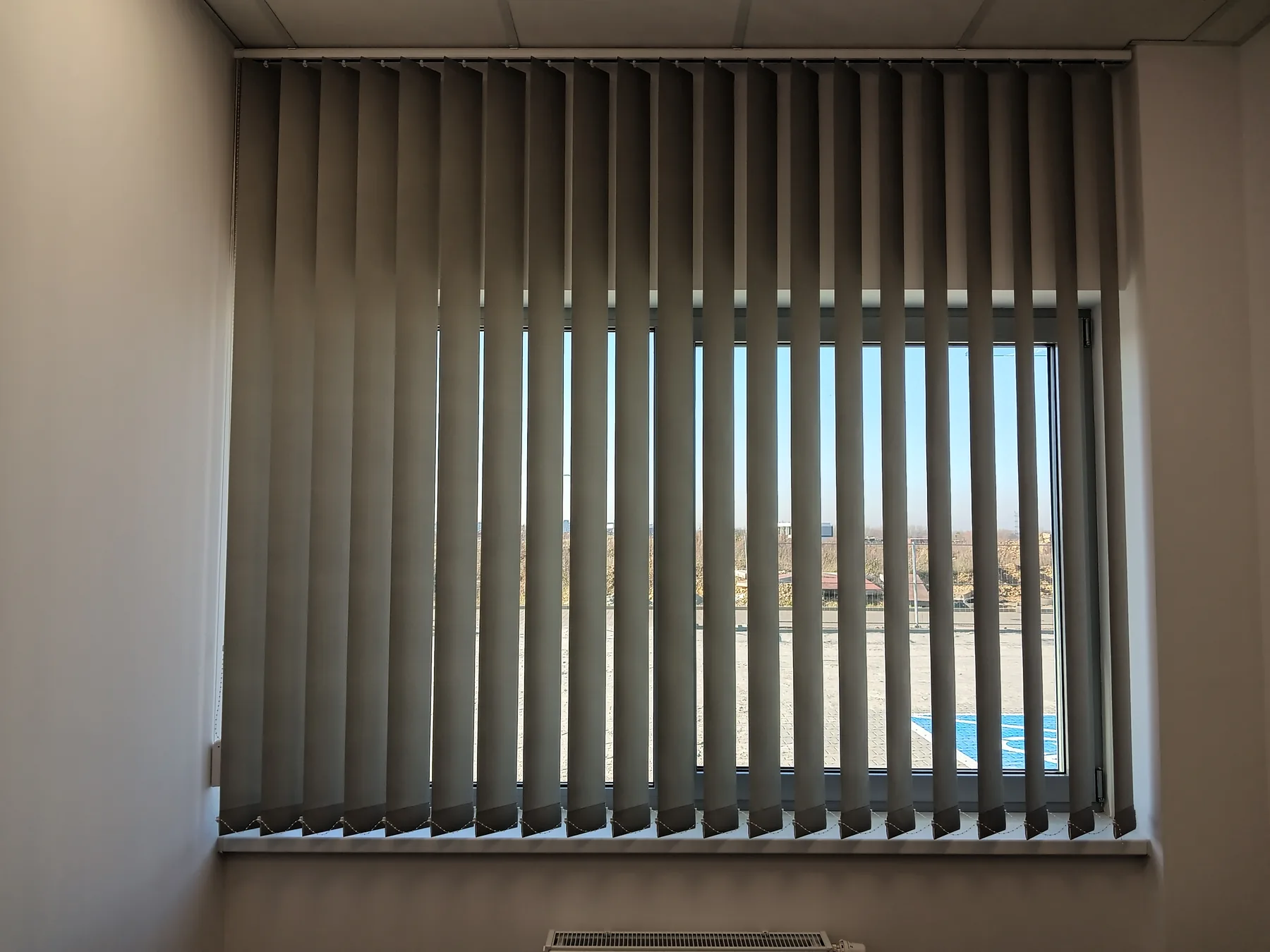 Żaluzje pionowe przy szerokim przeszkleniu w realizacji w Tarnowskich Górach - widok szerokiego przeszklenia z pionowymi lamelami